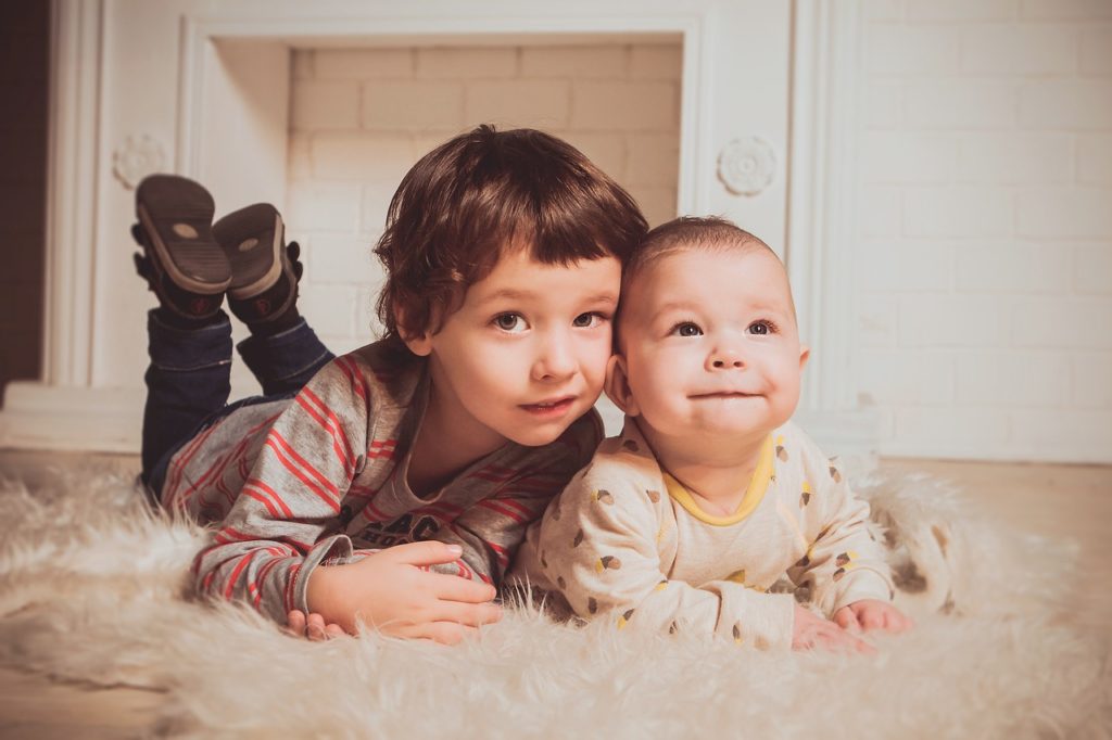 Grand frère à plat ventre avec son petit frère - second bébé