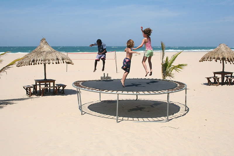 enfant jouant au trampoline devant la mer
